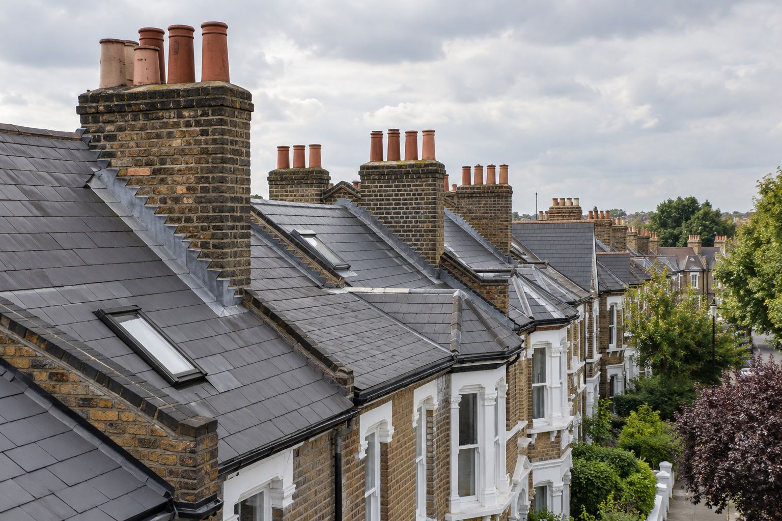 Slate roofs and brick chimney stacks along a London terrace